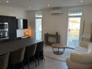 Séjour lumineux avec cuisine ouverte et vue sur le port de Sète